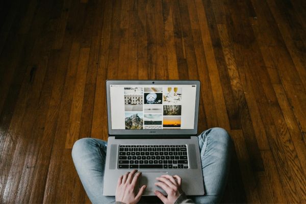 woman using computer while on a refinished hardwood floor